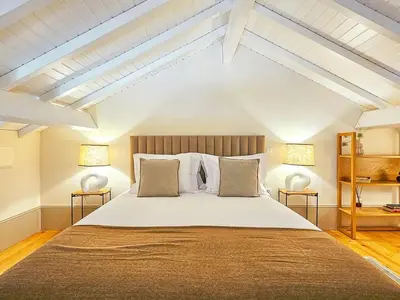 a bedroom with a large bed with two lamps at Wood Haven Luxury Duplex Downtown Porto with AC in Porto