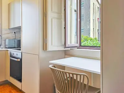 a kitchen with a chair and a window at Wood Haven Luxury Duplex Downtown Porto with AC in Porto