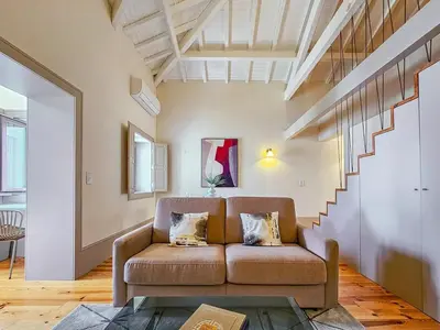 a living room with a couch and a staircase at Wood Haven Luxury Duplex Downtown Porto with AC in Porto