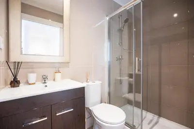 a bathroom with a toilet and a glass shower at FLH Porto Central TownHouse in Porto