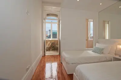 a white room with two beds and a window at Bolhão Nobre Apartments in Porto
