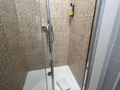 a shower stall with a glass door with a toilet at Happy Mountain in Porto