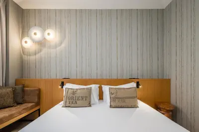a bedroom with a bed with two pillows and a couch at Descobertas Boutique Hotel by Aspasios in Porto