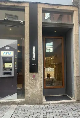 an entrance to a store with a dog in the window at Descobertas Boutique Hotel by Aspasios in Porto
