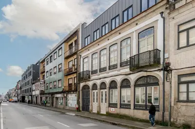 a man walking down a street next to buildings at Topazio Apartment by Porto Stories in Porto