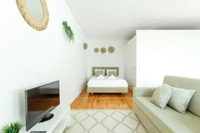 a living room with a couch and a television at Home M apartments in Porto