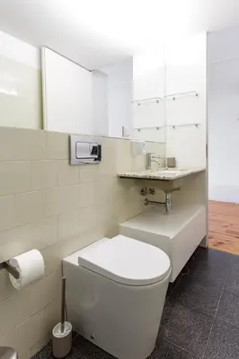a white bathroom with a toilet and a sink at Home M apartments in Porto