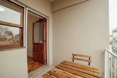 a wooden bench sitting in a room with a window at Cedofeita Flat by Hosty in Porto