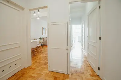 a hallway with a white door and a dining room at Cedofeita Flat by Hosty in Porto