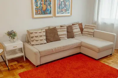 a living room with a couch and a red rug at Cedofeita Flat by Hosty in Porto