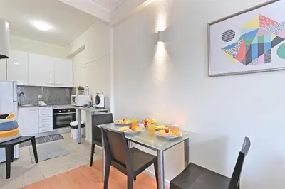 a kitchen and dining room with a table and chairs at Breeze Oporto Boavista Terrace in Porto