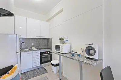 a kitchen with white cabinets and a counter top at Breeze Oporto Boavista Terrace in Porto