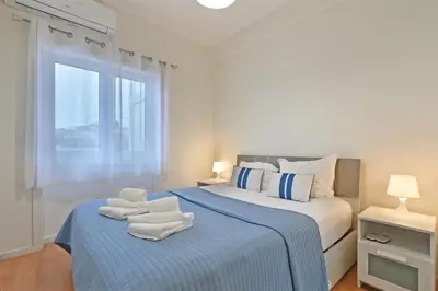 a white bedroom with a bed with towels on it at Breeze Oporto Boavista Terrace in Porto