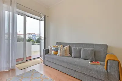 a living room with a couch and a large window at Breeze Oporto Boavista Terrace in Porto