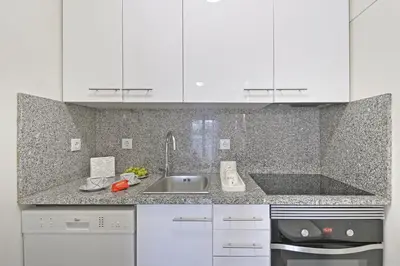 a kitchen with white cabinets and a sink at Breeze Oporto Boavista Terrace in Porto