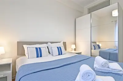 a bedroom with a large bed with blue and white pillows at Breeze Oporto Boavista Terrace in Porto