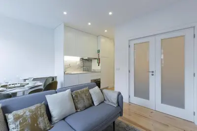 a living room with a couch and a kitchen at OPorto Cosy and Modern Loft in Porto