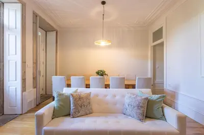 a dining room with a long table and a blue couch at Alegria Rubi - Urban Oasis with Garden in Porto