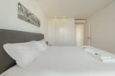 a bedroom with a large white bed with towels on it at Downtown Bright Apartment With Balcony by Vacationy in Porto