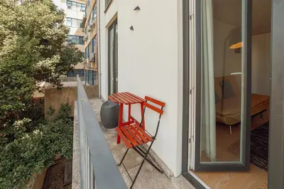 a dining room with a table and chairs and a chandelier at Downtown Bright Apartment With Balcony by Vacationy in Porto