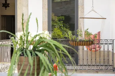 a balcony with two potted plants on a fence at Hidden Gem near city center- garden, outdoor kitchen, sauna in Porto
