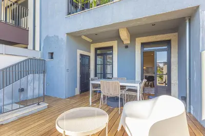 a patio with a table and chairs on a deck at Firmeza Gardens in Porto