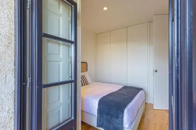 a bedroom with a bed and a glass door at Firmeza Gardens in Porto
