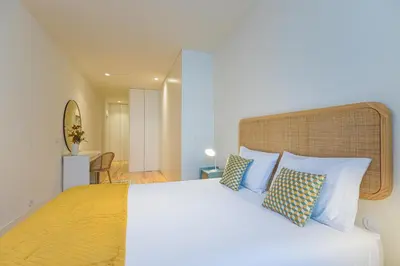 a bedroom with a large bed with blue pillows at Firmeza Gardens in Porto
