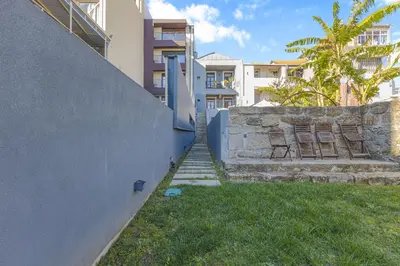 a stairway leading up to a wall with two chairs at Firmeza Gardens in Porto