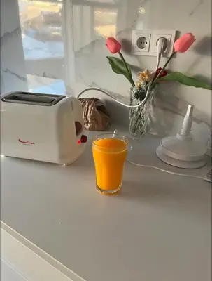 a kitchen counter with a toaster and a glass of orange juice at Apartamento centro histórico Porto in Porto