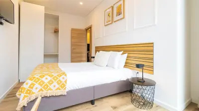 a bedroom with a large bed with a wooden headboard at Trendy 2BR Near Douro River by LovelyStay in Vila Nova de Gaia
