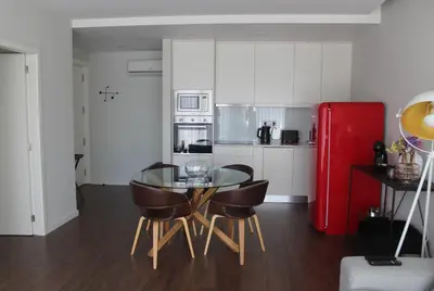 a kitchen with a glass table and chairs and a red refrigerator at My Oporto Apartment in Porto