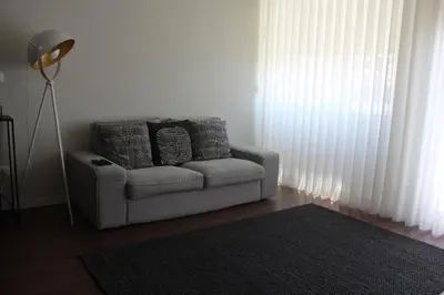 a living room with a chair and a floor lamp at My Oporto Apartment in Porto
