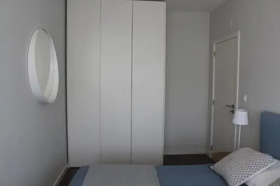 a bedroom with a mirror and a bed and a lamp at My Oporto Apartment in Porto