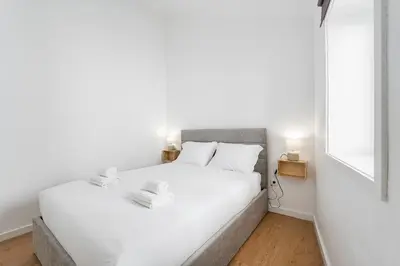 a white bedroom with a large bed with white sheets at GuestReady - Oporto Old Town House 3 in Porto
