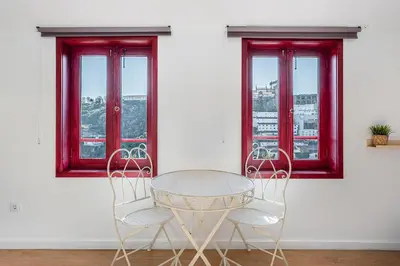 a table and two chairs in front of two windows at GuestReady - Oporto Old Town House 3 in Porto