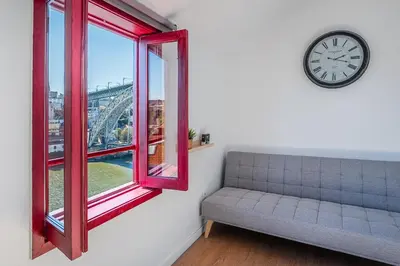 a room with a couch and a clock and a window at GuestReady - Oporto Old Town House 3 in Porto