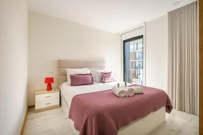 a bedroom with a bed with two towels on it at Wonderfull apartment Campanhã Train station with parking in Porto