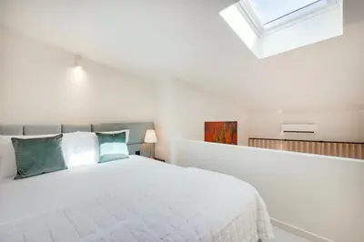 a bed with a table with a lamp on it at Porto Center Duplex | Edifício Terracotta in Porto