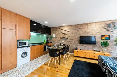 a kitchen and living room with a table and chairs at Merc Porto Downtown's Place in Porto