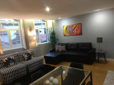 a living room with a couch and a table at Merc Porto Downtown's Place in Porto