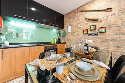 a kitchen with a table with plates and wine glasses at Merc Porto Downtown's Place in Porto