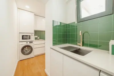 a kitchen with a sink and a washing machine at Lapa Stylish Apartments by Vacationy in Porto