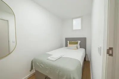a small bedroom with a bed and a mirror at Lapa Stylish Apartments by Vacationy in Porto
