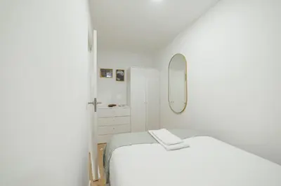 a white room with a bed and a mirror at Lapa Stylish Apartments by Vacationy in Porto