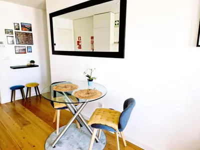 a dining room with a glass table and stools at Porto Trindade Balcony in Porto