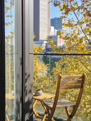 a wooden chair sitting next to a window with a table at Porto Trindade Balcony in Porto