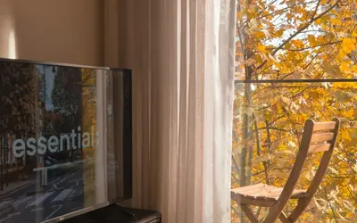 a chair sitting in front of a window with a television at Porto Trindade Balcony in Porto
