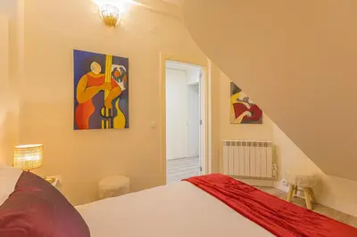 a bedroom with a bed and some paintings on the wall at Marilia's Garden Apartment in Porto