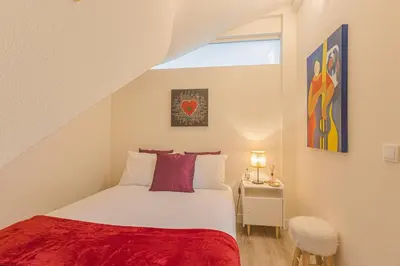 a small bedroom with a bed and a window at Marilia's Garden Apartment in Porto